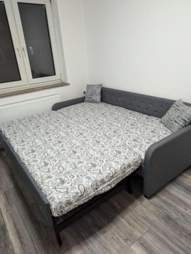 a bed sitting in a room next to a window at La vins Apartments in Bremen