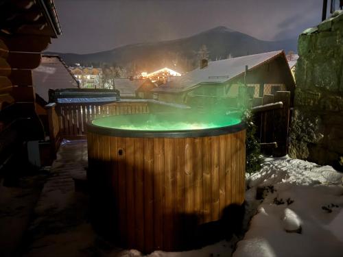a hot tub in the snow at night at Szafranowe Wzgórze II-Dom z parkingiem, Sauna, zew Jacuzzi in Karpacz