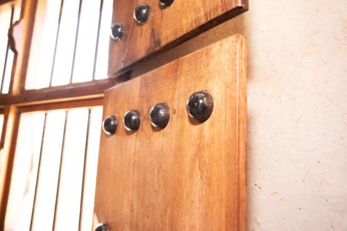 a wooden door with black hinges on a wall at Nomad Inn Nizwa in Nizwa