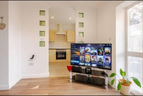 a living room with a flat screen tv on a wall at Spacious 2BDR Apartment, WIFI+ Great TV in Romford