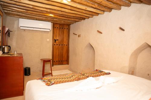 a bedroom with a bed and a wooden ceiling at Nomad Inn Nizwa in Nizwa