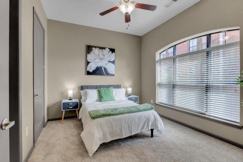 タルサにあるCozy 2BR- Pool,Gym,Pkng,Near BOK Ctr&Arts Dstrctのベッドと天井扇風機のある寝室