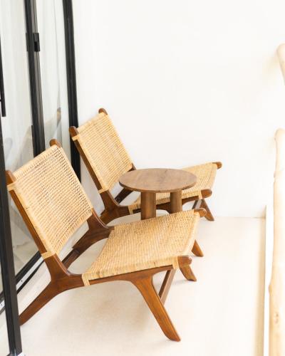 two chairs and a wooden table and chairs at Tyde Bali Boutique Hotel in Uluwatu