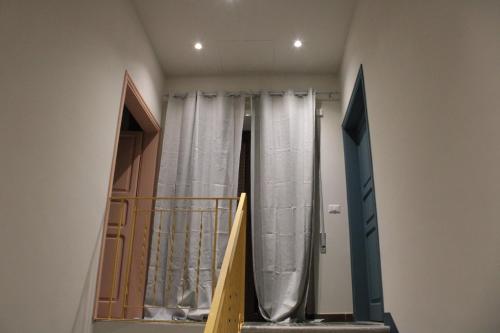 a stairway with a door and curtains in a room at A Casa di Nonna in SantʼAngelo in Theodice