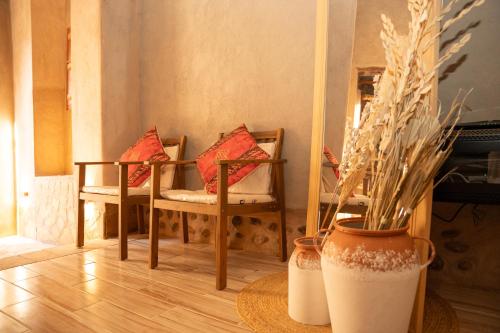 a room with two chairs and a table with pillows at Nomad Inn Nizwa in Nizwa