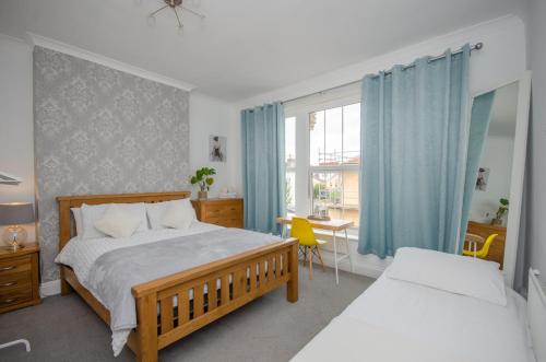 a bedroom with a bed and a table with a yellow chair at Stylish 91sqm Victoria 2 bedroom Apartment in Bristol