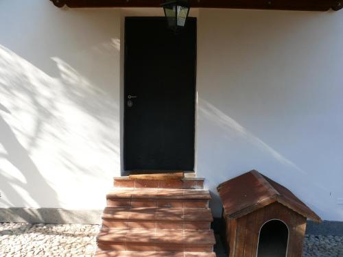 a house with a black door and a dog house at Villetta Aleanto in Mentana