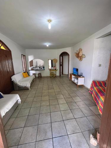 a living room with two beds and a tiled floor at Casa com vista mar. Um paraíso próximo à praia! in Ilhéus