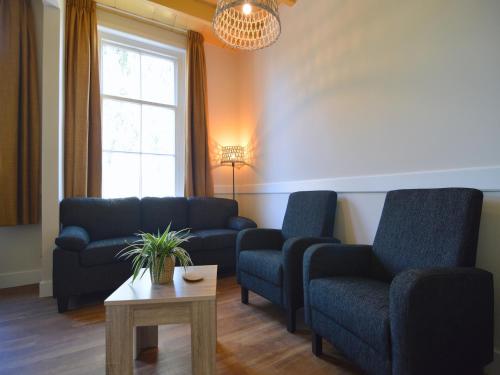 a living room with two couches and a table at Farmhouse in Geesteren near Forests in Geesteren