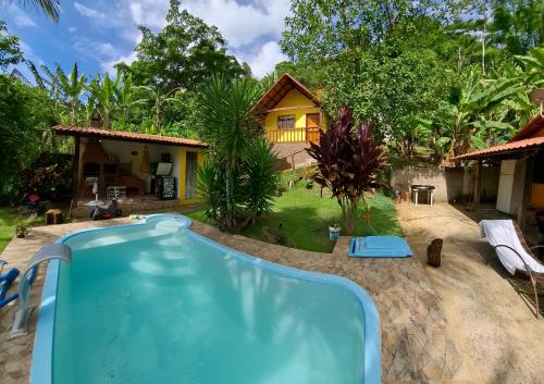 a resort with a pool and a house at Recanto Casa Amarela de São Romão in Nova Friburgo