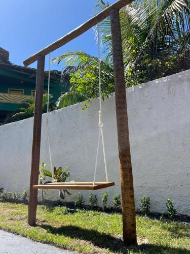 a swing hanging from a pole in the grass at Casa com vista mar. Um paraíso próximo à praia! in Ilhéus