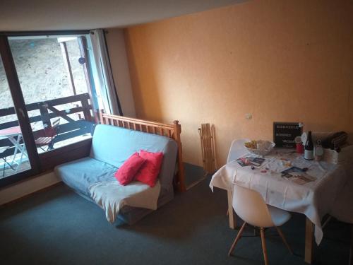 une chambre avec une table, une chaise et une table avec dans l'établissement Appartement calme, 6 pers, résidence la Barbade, à Les Deux Alpes