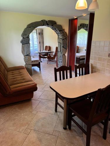 a living room with a table and a stone wall at Apartament I Chochołów 162c in Chochołów
