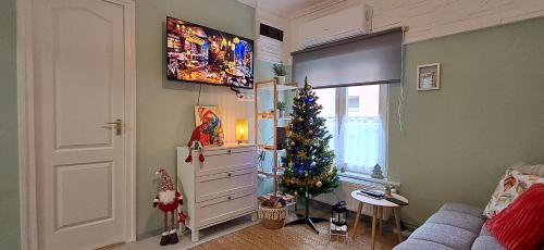 a living room with a christmas tree and a television at Igali Varázs Apartman 150 méter a fürdőtől in Igal