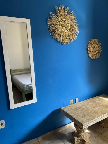 a blue room with a mirror and a table at Casa com vista mar. Um paraíso próximo à praia! in Ilhéus