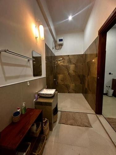 a bathroom with a shower and a sink at Maneri Villa and Apartments in Zanzibar City