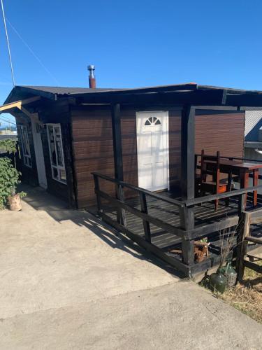 a small house with a white window and a porch at Casa de Mar in Quellón