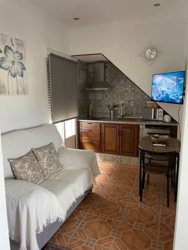 a bedroom with a bed and a table and a kitchen at Casa de la Miel in Setenil