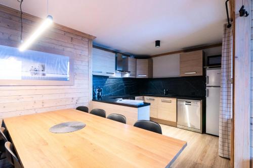- une cuisine avec une table et des chaises en bois dans la chambre dans l'établissement Chalet Mouflon - 5 Pièces pour 8 Personnes MAE-1751, à Val Thorens