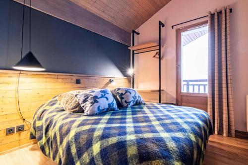 une chambre avec un lit avec une couverture bleue et blanche dans l'établissement Chalet Mouflon - 5 Pièces pour 8 Personnes MAE-1751, à Val Thorens