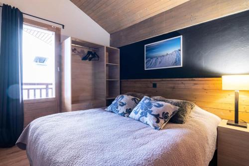 une chambre avec un lit avec un mur bleu dans l'établissement Chalet Mouflon - 5 Pièces pour 8 Personnes MAE-1741, à Val Thorens