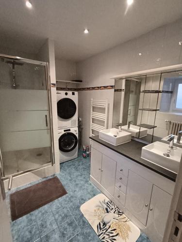 une salle de bain avec deux lavabos et une machine à laver dans l'établissement Chambre à l étage, à Plémet