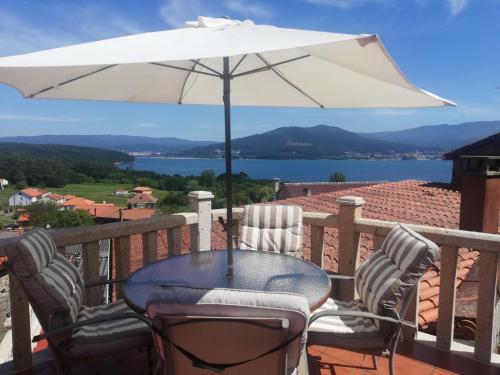 un tavolo e sedie con un ombrellone su un balcone di Casa Consuelo a Sabardes