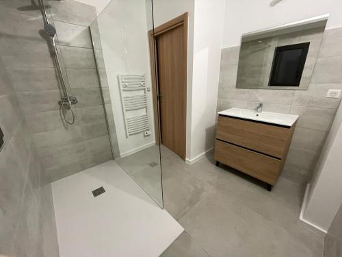 une salle de bain avec une douche, un lavabo et un miroir dans l'établissement Villa Casa di sognu, à Lecci