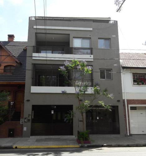 a building with two garage doors and a tree in front at InspireBA - Terrace in Buenos Aires