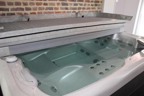 une baignoire dans une salle de bain avec dans l'établissement Aux p'tits bonheurs la grange, à Neuve-Chapelle