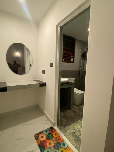 a bathroom with a mirror and a sink and a toilet at Eco Vibe Villa Hiriketiya in Dickwella