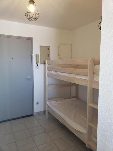 Cette chambre comprend des lits superposés et une porte. dans l'établissement Vue sur la mer, à Valras-Plage