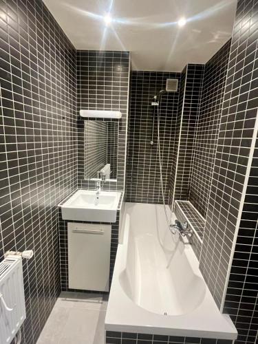 une salle de bain avec une baignoire et un lavabo dans l'établissement Charmant appartement à 2 min de Paris, à Ivry-sur-Seine