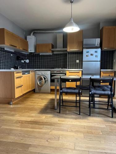 une cuisine avec des armoires en bois et une table et des chaises dans l'établissement Charmant appartement à 2 min de Paris, à Ivry-sur-Seine