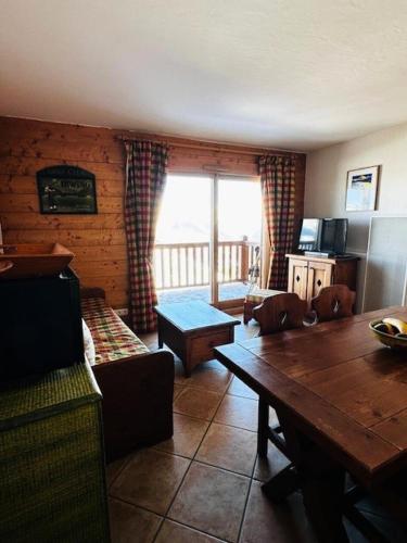 un salon avec un canapé et une table dans l'établissement Résidence Saint Bernard - Appartement de charme pour 6 personnes, dans une résidence skis aux pieds avec accès piscine et parking privé dans le village du MAE-8971, à Arc 1800