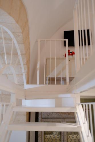 a white spiral staircase in a room with a stair case at SASSO BIANCO in Matera