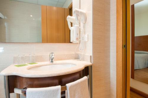 un baño con lavabo y espejo en ibis Styles Pamplona Noain, en Noáin