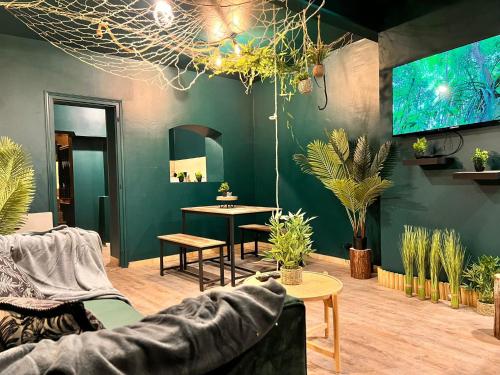 a living room with a couch and a table with plants at L'Amazonia - Private spa in Boulogne-sur-Mer