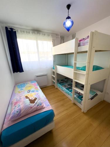 une chambre avec deux lits superposés et une fenêtre dans l'établissement Appartement familial, à 10mn de Disneyland, à Montévrain