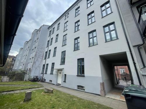 a large white building with a large garage at Quiet apartment, trendy Grünerlokka in Oslo