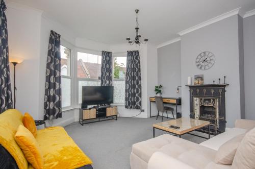 a living room with a couch and a fireplace at Stylish 91sqm Victoria 2 bedroom Apartment in Bristol