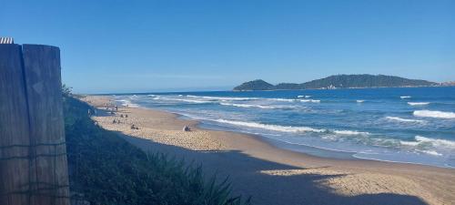 フロリアノポリスにあるCampin novas palmeiras 953の砂浜と海を歩く人々のいる浜