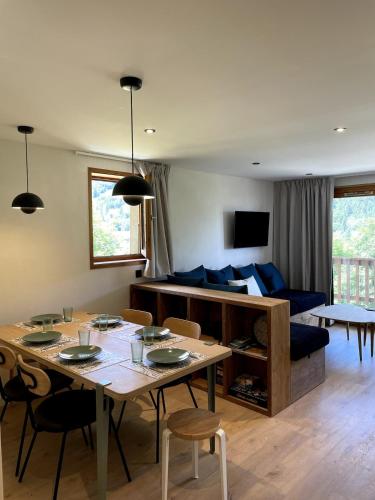 un salon avec une table et un canapé bleu dans l'établissement Meribel Centre Mountain View, à Mussillon