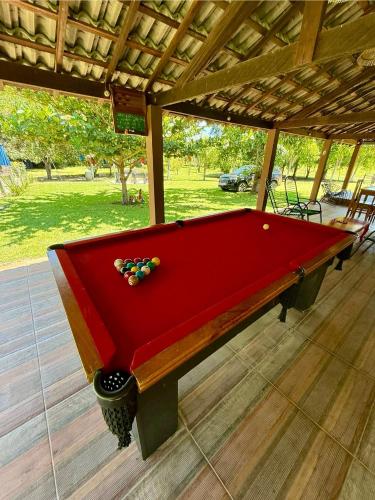 a red pool table sitting on a patio at Sítio Chalako, casa exclusiva às margens do Rio Mimoso in Bonito