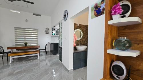a bathroom with a sink and a mirror and a table at Uthuppan's Bedroom with the waterfall view in Ūdumbanshola
