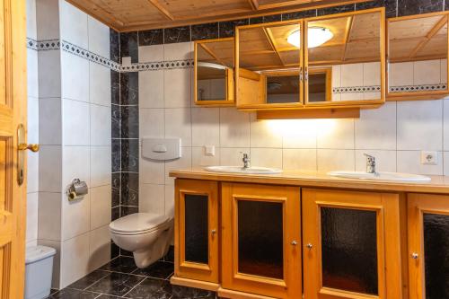 a bathroom with two sinks and a toilet at Steffa Hamat in Ischgl