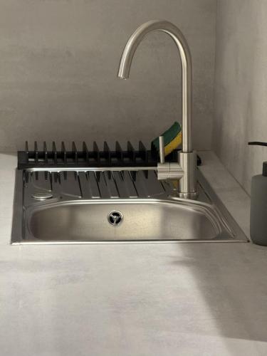 a stainless steel kitchen sink with a faucet at La Baie de Somme RDC in Abbeville