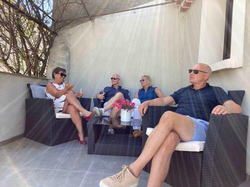 a group of people sitting in chairs on a patio at Modern apartment large terrace and beautiful view in Quarante