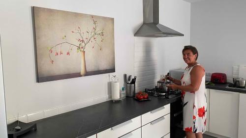 a woman standing in a kitchen with a counter at Modern apartment large terrace and beautiful view in Quarante