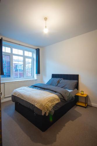 ein Schlafzimmer mit einem Bett und einem Fenster in der Unterkunft Urban Luxe Stays - Purbrook Bridge in London